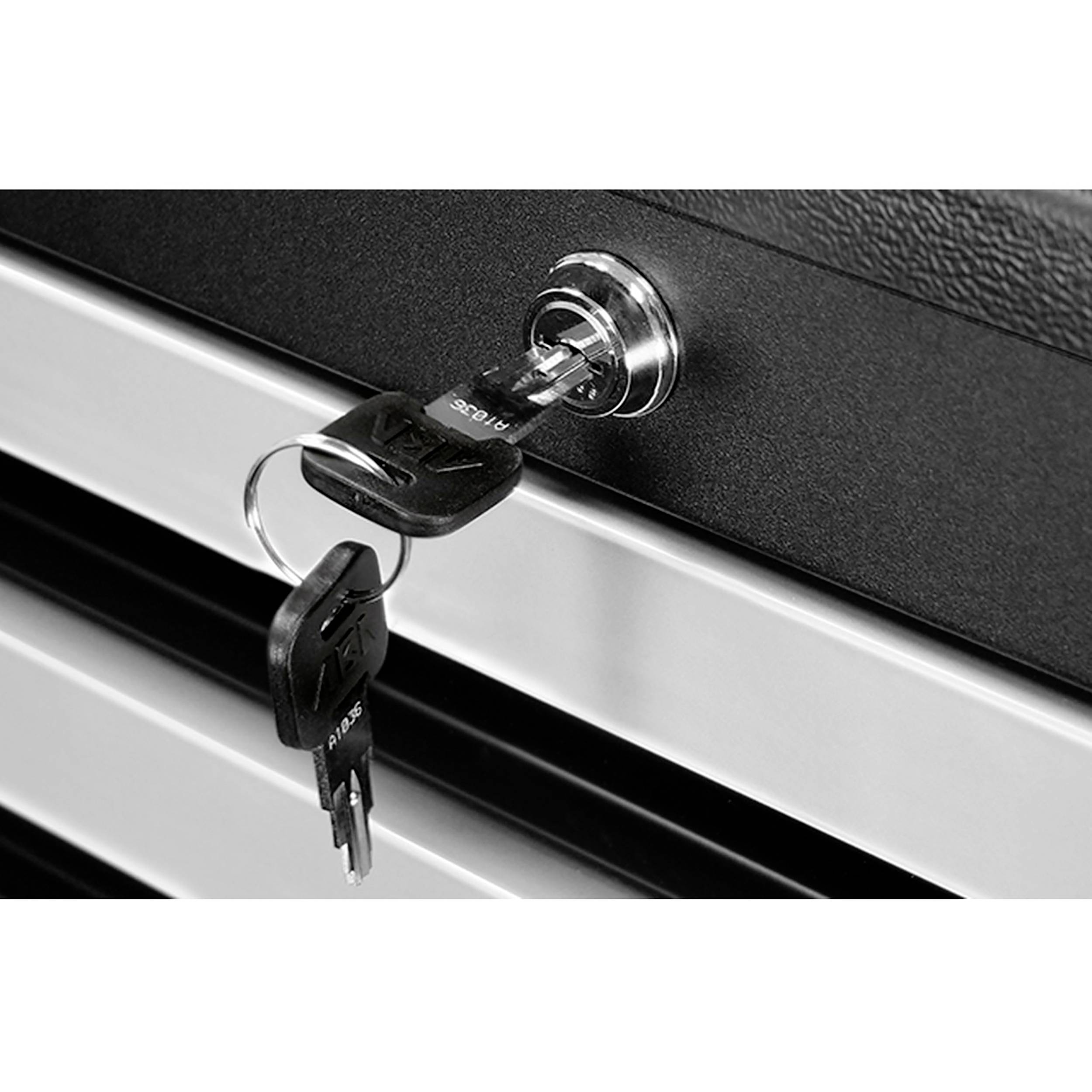 Klucz tkwi w zamku metalowej szafki. Szafka składa się z kilku szuflad.