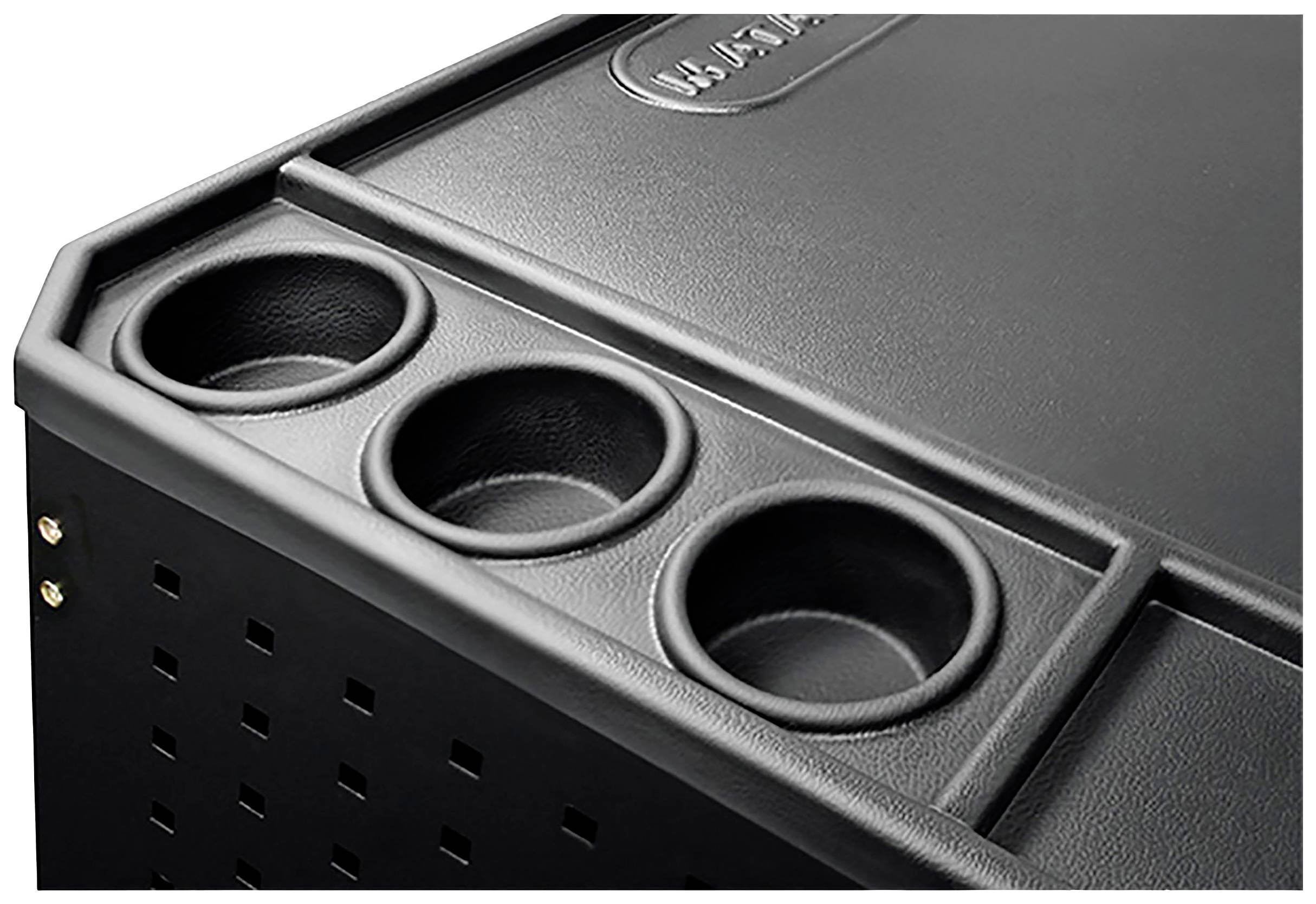 Fragment obrazu przedstawia czarną osłonę urządzenia z trzema okrągłymi zagłębieniami, prawdopodobnie przeznaczonymi do odkładania przedmiotów.