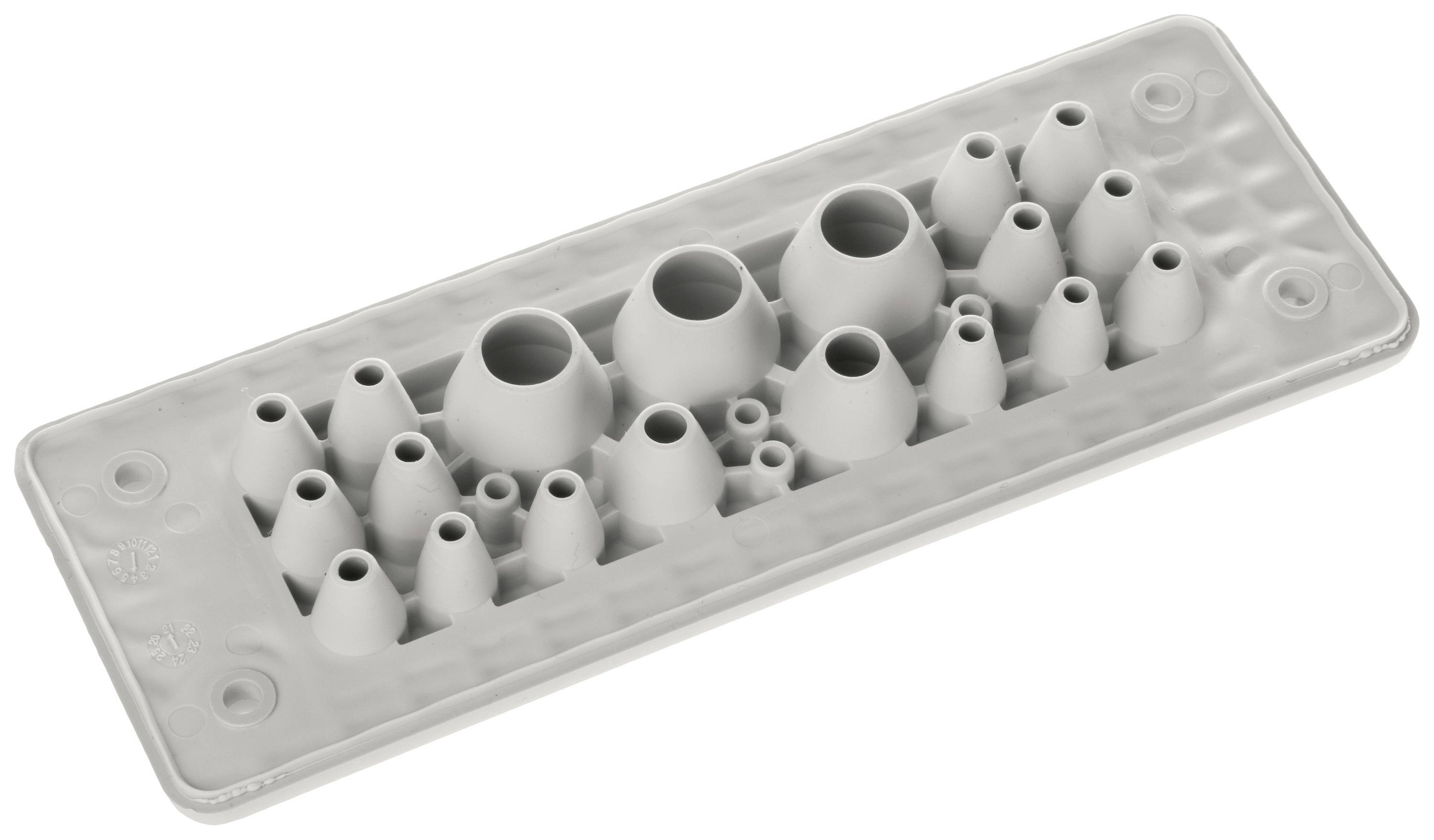 Szary element z tworzywa sztucznego, prostokątny, z kilkoma otworami stożkowymi i okrągłymi. Stosowany do uszczelniania kabli lub rur.