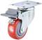 Obrotowe kółko skrętne z czerwonym bieżnikiem i szarym pedałem hamulcowym, zamontowane na płytce mocującej do mebli lub wózków.