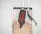 Dłoń trzyma miernik napięcia przy otwartej skrzynce elektrycznej z widocznymi przewodami.