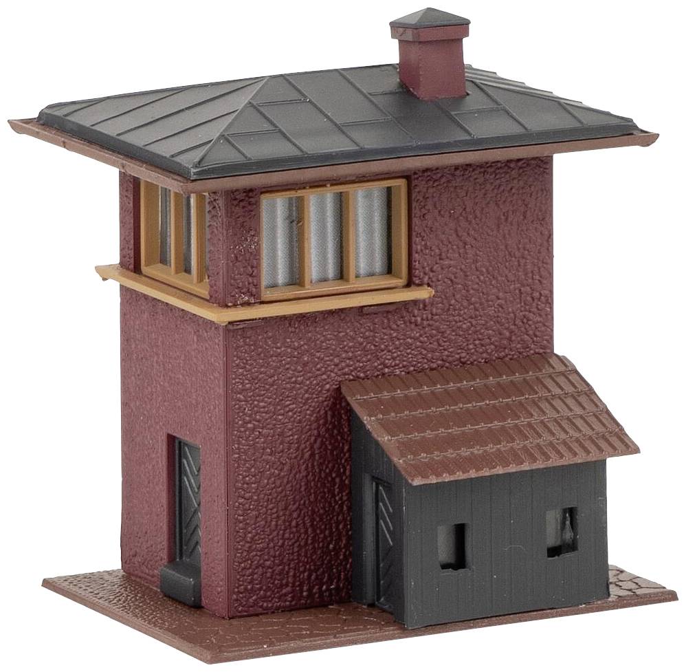 Mały, czerwono-brązowy model budynku z ciemnym dachem, kwadratowymi oknami i dobudówką po prawej stronie.