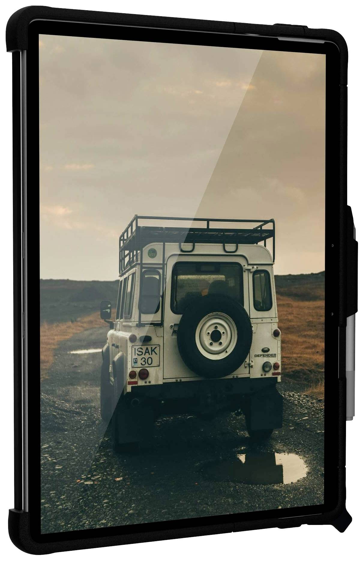 Terenowy samochód jedzie błotnistą drogą przez wiejski krajobraz, podczas gdy niebo jest zachmurzone.
