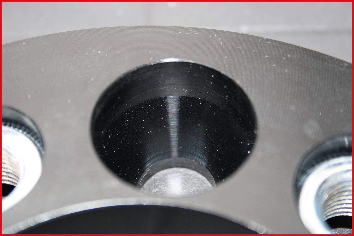 Zbliżenie metalowego elementu z wieloma okrągłymi otworami, prawdopodobnie części urządzenia mechanicznego lub technicznego.