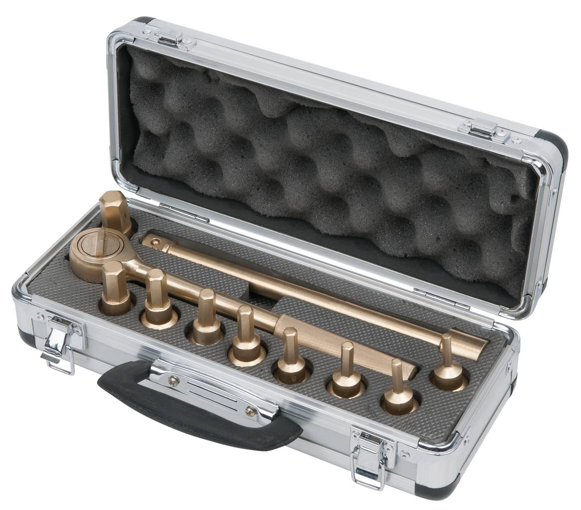 Srebrna walizka z czarną rączką zawiera zestaw narzędzi w kolorze mosiądzu z odpowiednimi wkładkami, ułożonymi na piance.