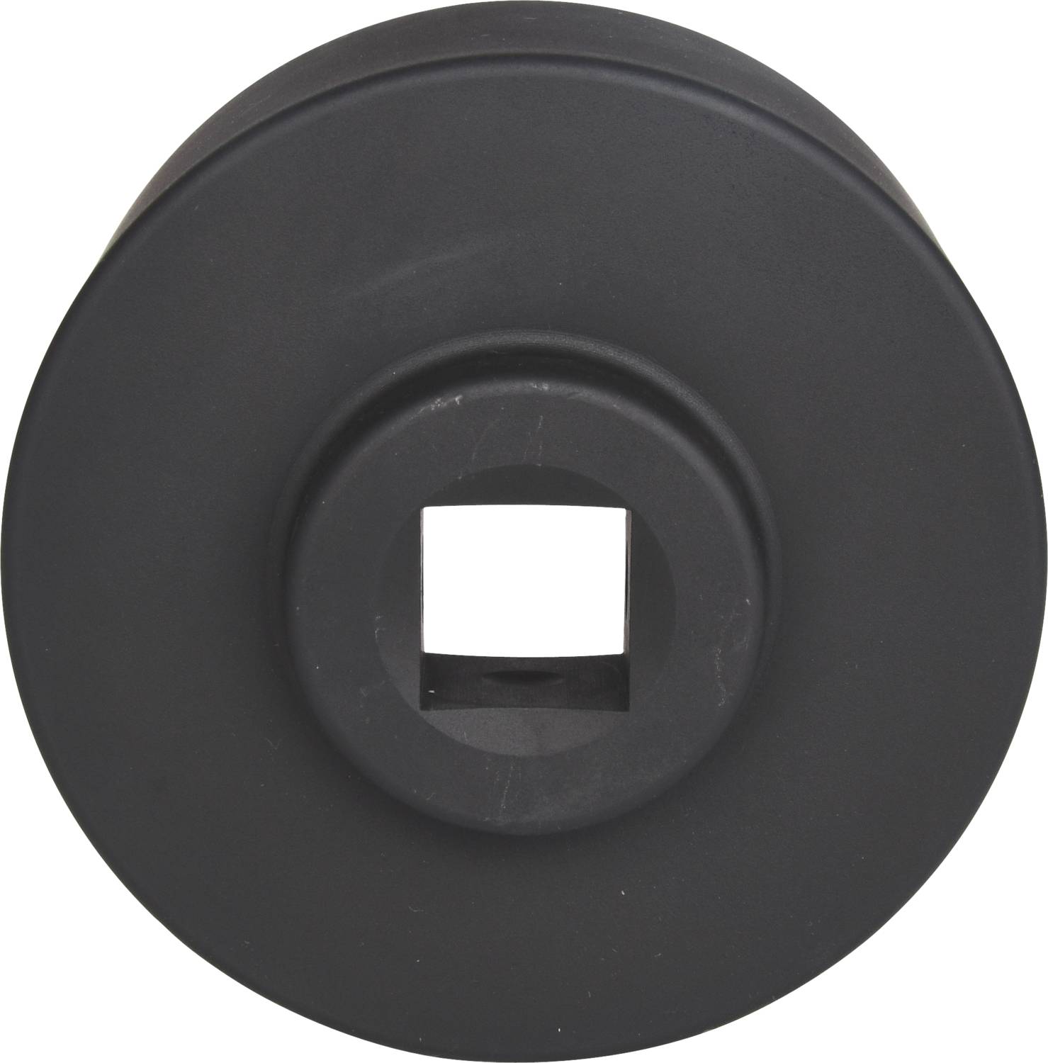 Czarny, okrągły element z kwadratowym otworem pośrodku. Wygląda na adapter narzędziowy lub element napędowy.