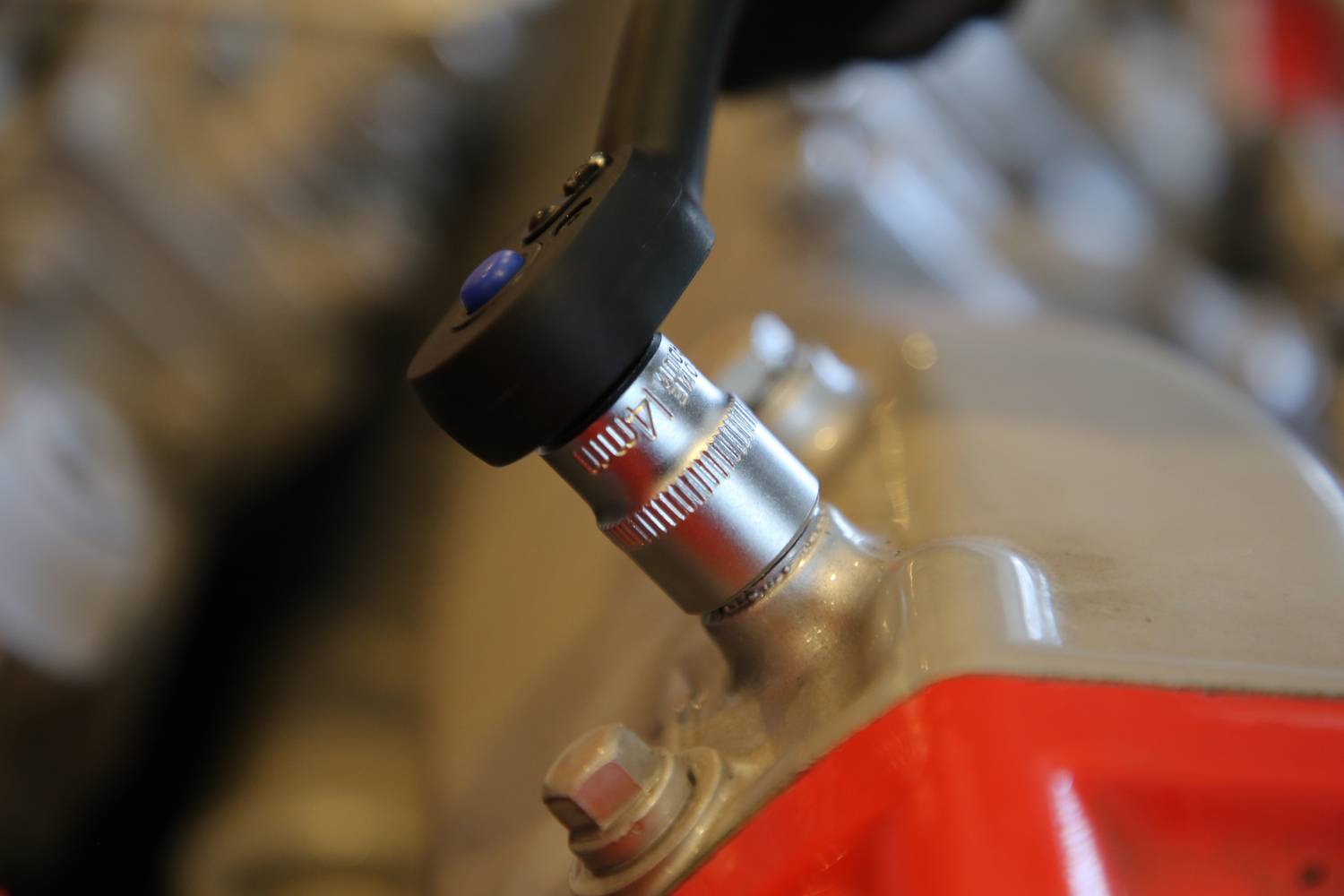 Zbliżenie klucza płaskiego podczas pracy przy metalowym złączu. Tło jest rozmyte, z naciskiem na proces dokręcania śruby.