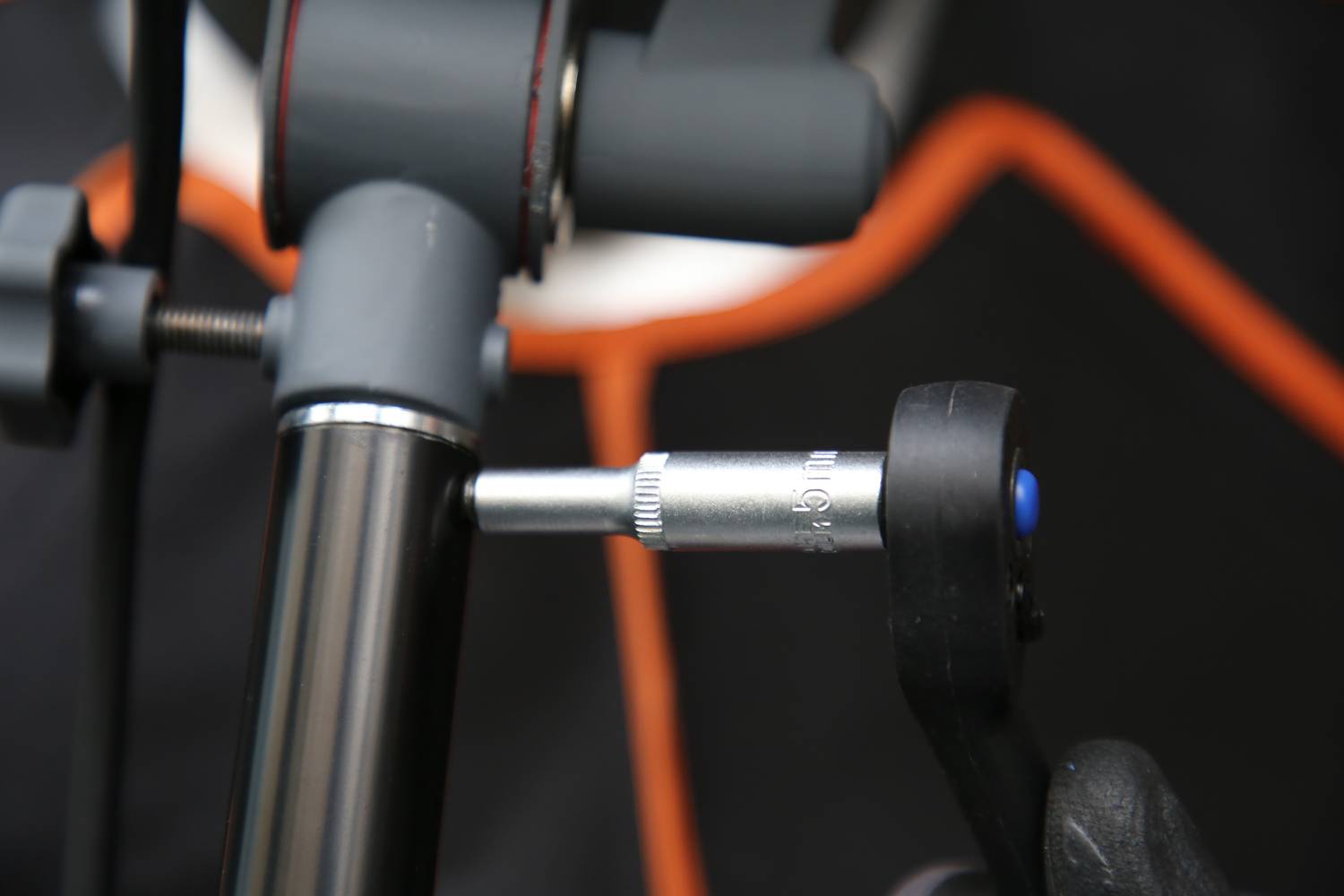 Zbliżenie montażu roweru, podczas którego srebrne narzędzie jest używane do przykręcania śruby roweru.