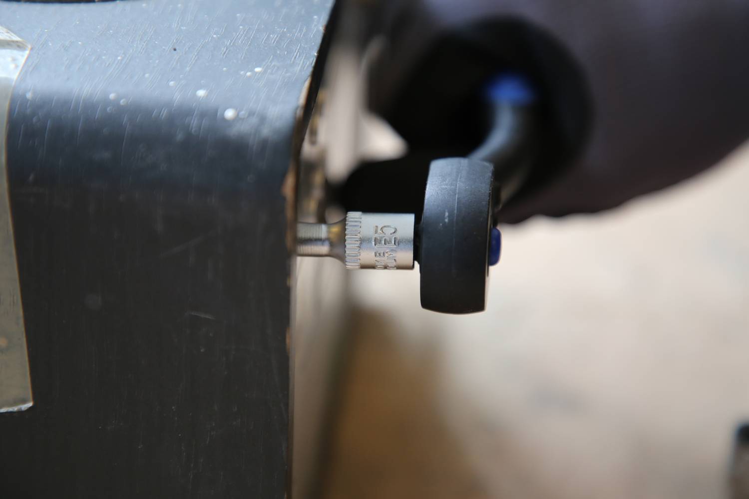 Zbliżenie miernika z podziałką od 0 do 100 barów. Dłoń trzyma uchwyt, aby obsłużyć urządzenie.