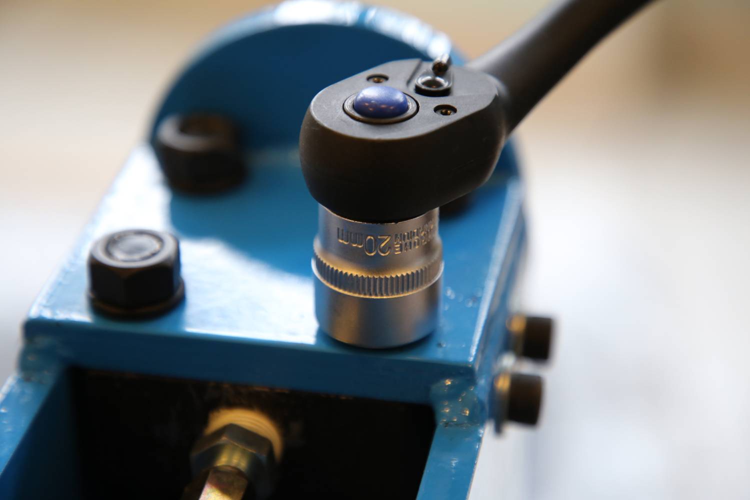 'Zbliżenie niebieskiego urządzenia mechanicznego z dźwignią i cylindryczną metalową częścią wyświetlającą liczby.'