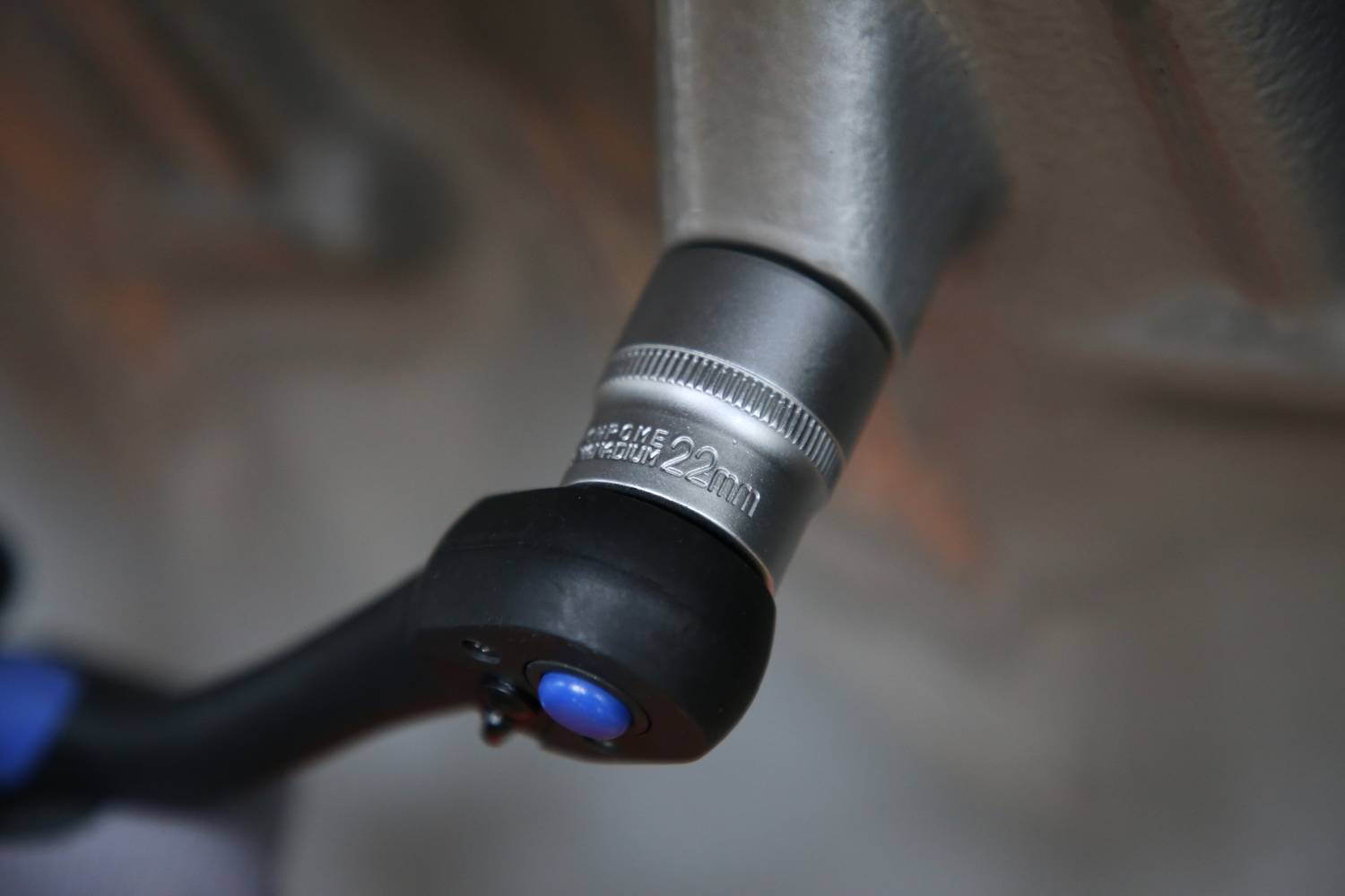 Zbliżenie pedału rowerowego z metalowym elementem, na którym wydrukowano '22 mm', prezentujące szczegół części roweru.