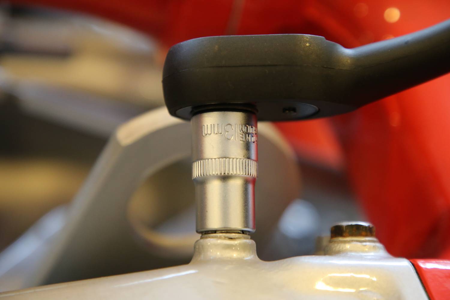 Zbliżenie klucza płaskiego, który jest używany do dokręcania śruby. Scena prezentuje precyzyjne posługiwanie się narzędziem.