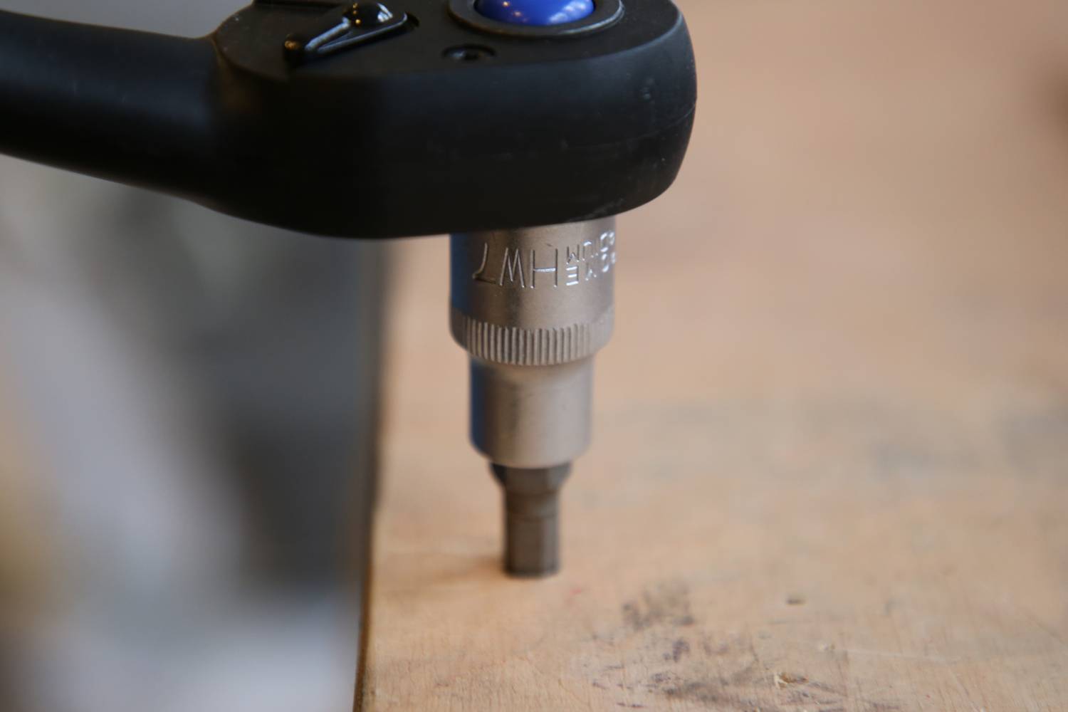 Wkrętarka akumulatorowa wkręca śrubę w drewnianą powierzchnię. Zbliżenie urządzenia ze szczególnym uwzględnieniem końcówki wiertniczej.