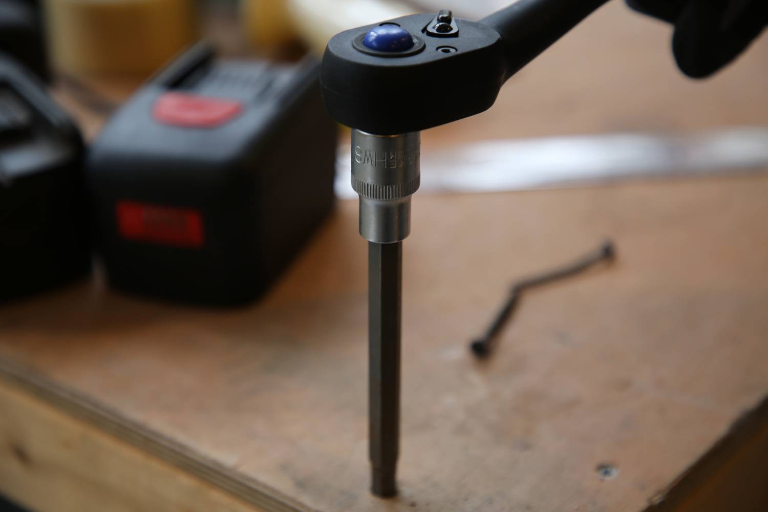 Wiertarka na stole warsztatowym ze szczególnym uwzględnieniem głowicy wiertniczej. W tle widoczne są nieostre narzędzia.