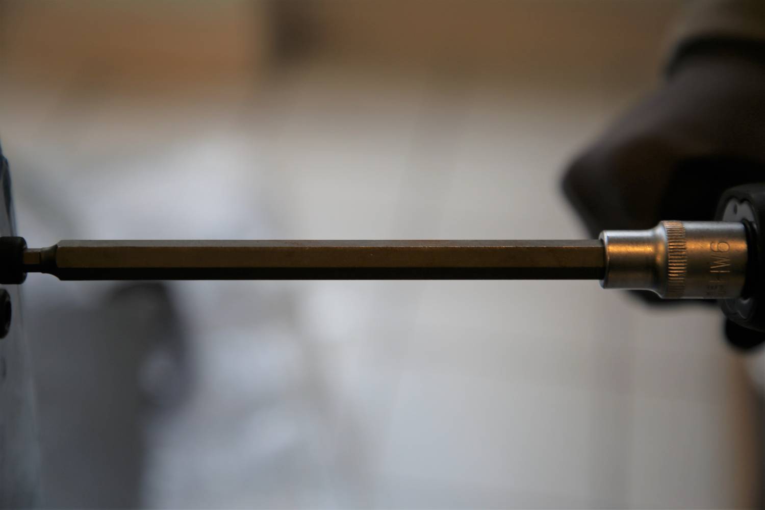 Zbliżenie wkrętaka pracującego przy wkręcaniu śruby. Otoczenie jest rozmyte, co sprawia, że narzędzie pozostaje w centrum uwagi.