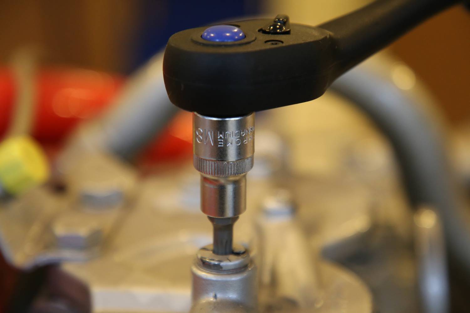 Mechaniczny klucz dynamometryczny dokręca śrubę w metalowym urządzeniu, aby zapewnić precyzyjne naprężenie.