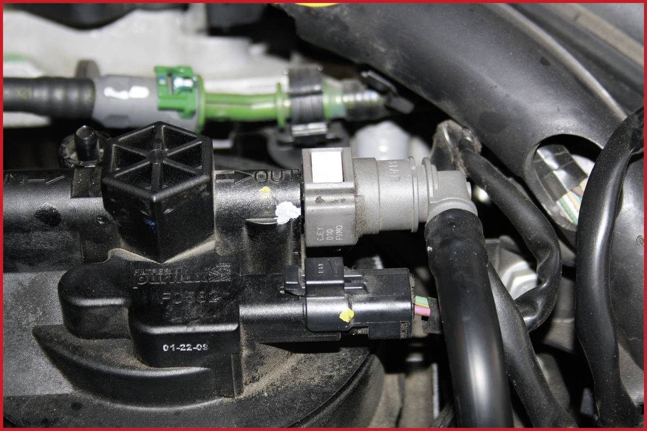 Komora silnika z widocznymi przewodami, czujnikami i kablami łączącymi różne elementy pojazdu.