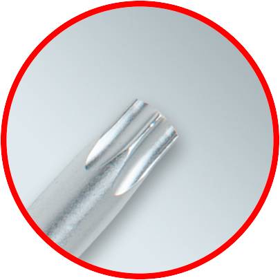 Zbliżenie metalowego, cylindrycznego obiektu o gładkiej powierzchni i zaokrąglonych krawędziach. Otoczony czerwonym kołem.