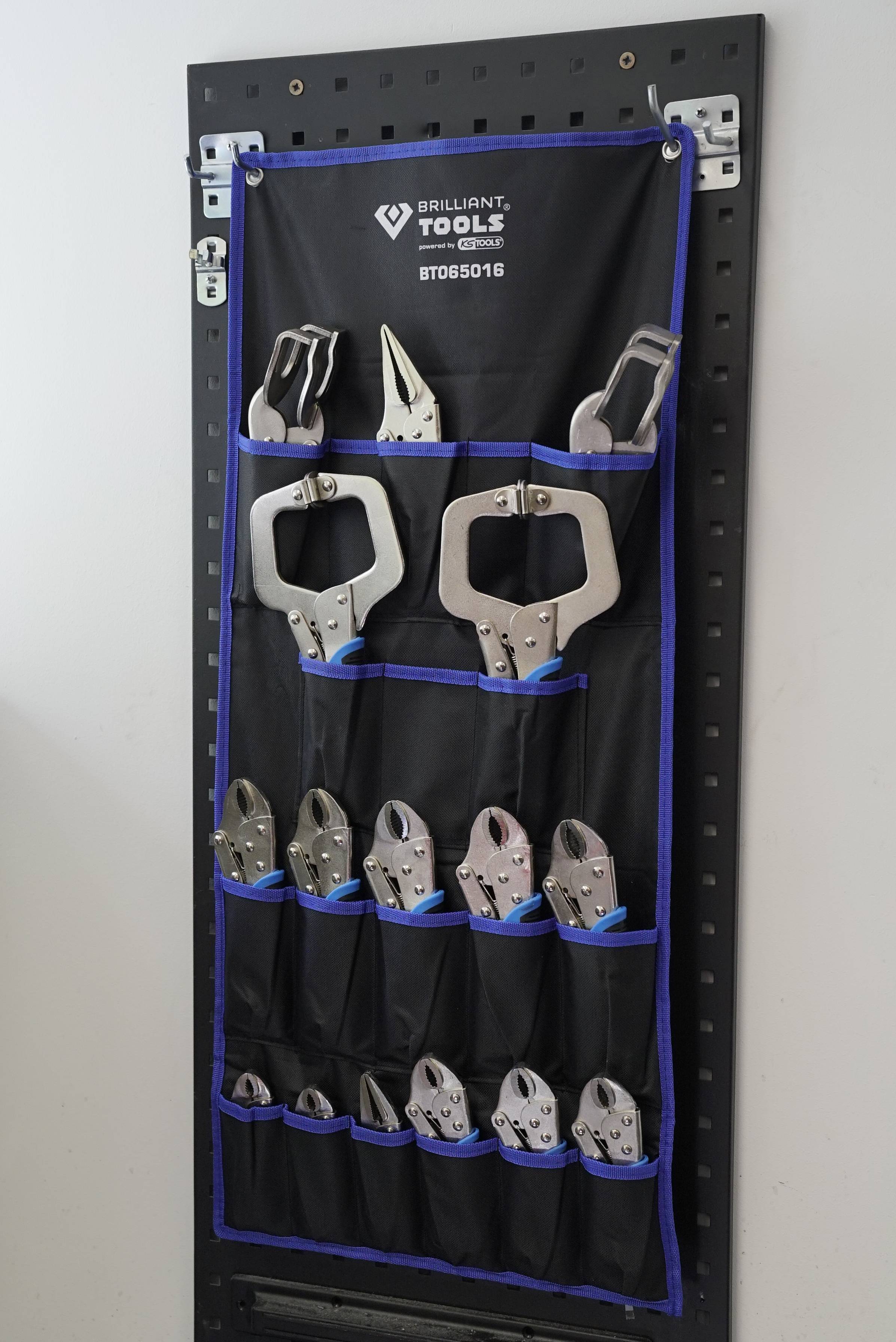 Czarna tablica organizera narzędzi z wieloma zaciskami śrubowymi w różnych rozmiarach, ułożonymi w schludny sposób.