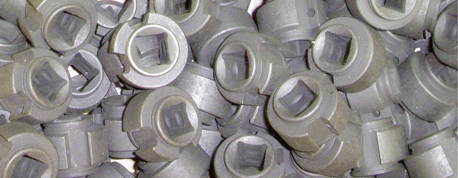 Zbliżenie plastikowych tulei ułożonych obok siebie. Mają cylindryczny kształt z kwadratowym otworem.