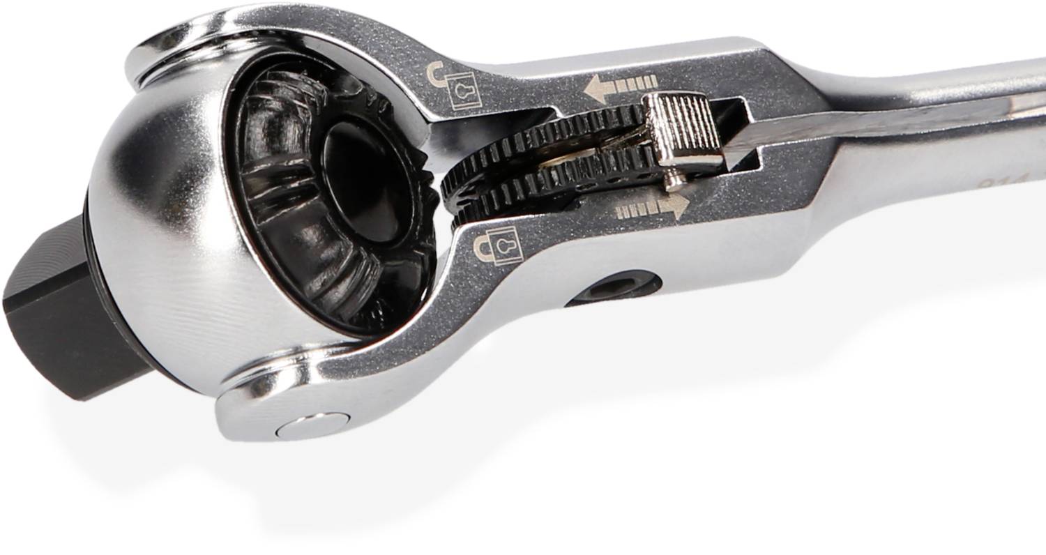 Zbliżenie klucza płaskiego z grzechotką i regulowaną głowicą. Widoczne są zęby mechanizmu zapadkowego oraz strzałka wskazująca kierunek ruchu.