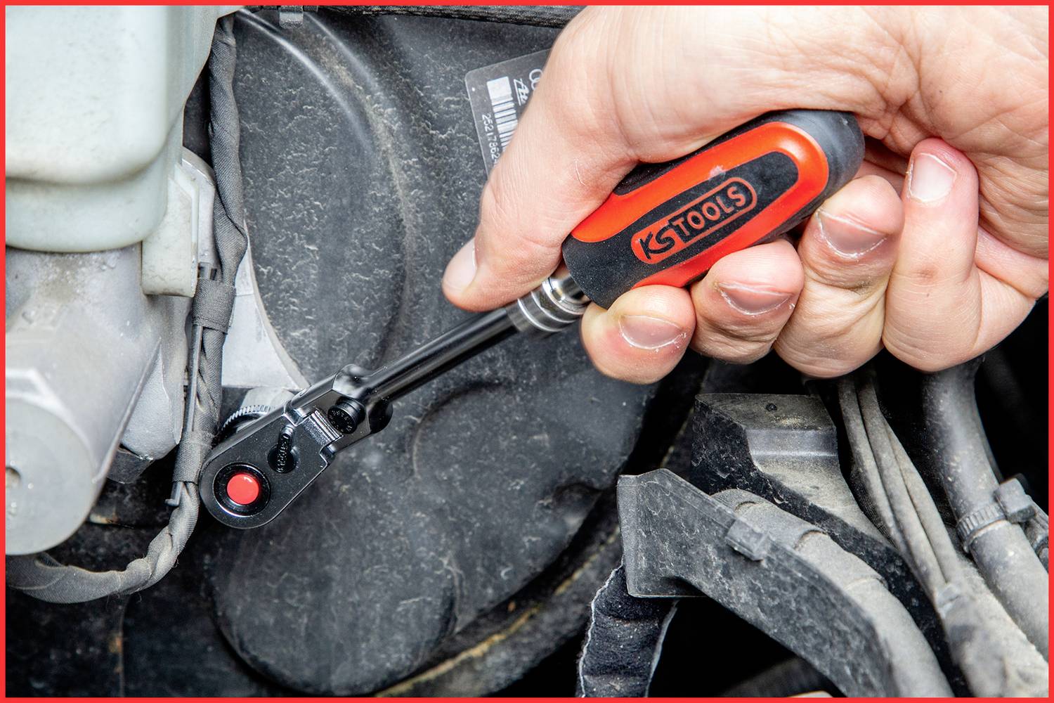 Dłoń używa klucza do dokręcenia śruby w części samochodowej.