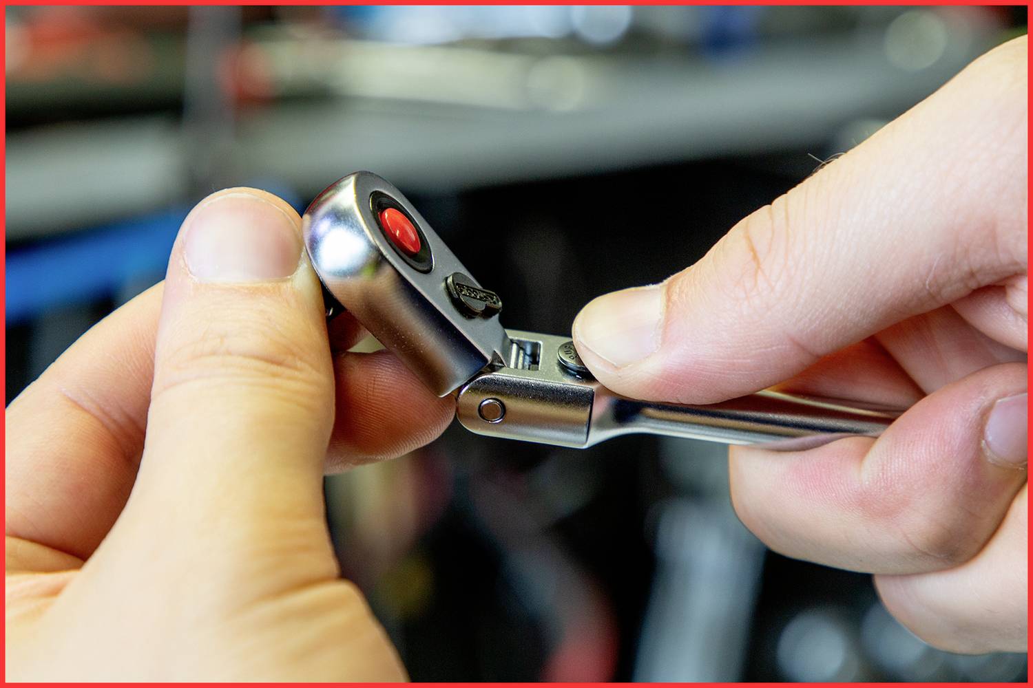 Zbliżenie dwóch dłoni obsługujących mechanizm zapadkowy narzędzia, ze szczególnym skupieniem na pokrętle regulacyjnym i zębackach.