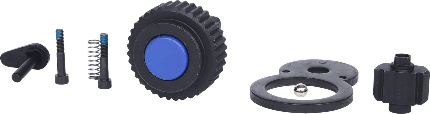 Rozebrany zestaw części mechanicznych, w tym duże koło zębate z niebieskim przyciskiem, sprężyny i małe elementy.