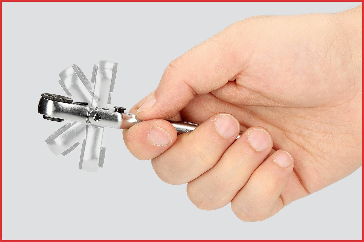 Ręka trzyma mały klucz nastawny z wieloma składanymi narzędziami, które są kompaktowe i praktyczne w podróży.