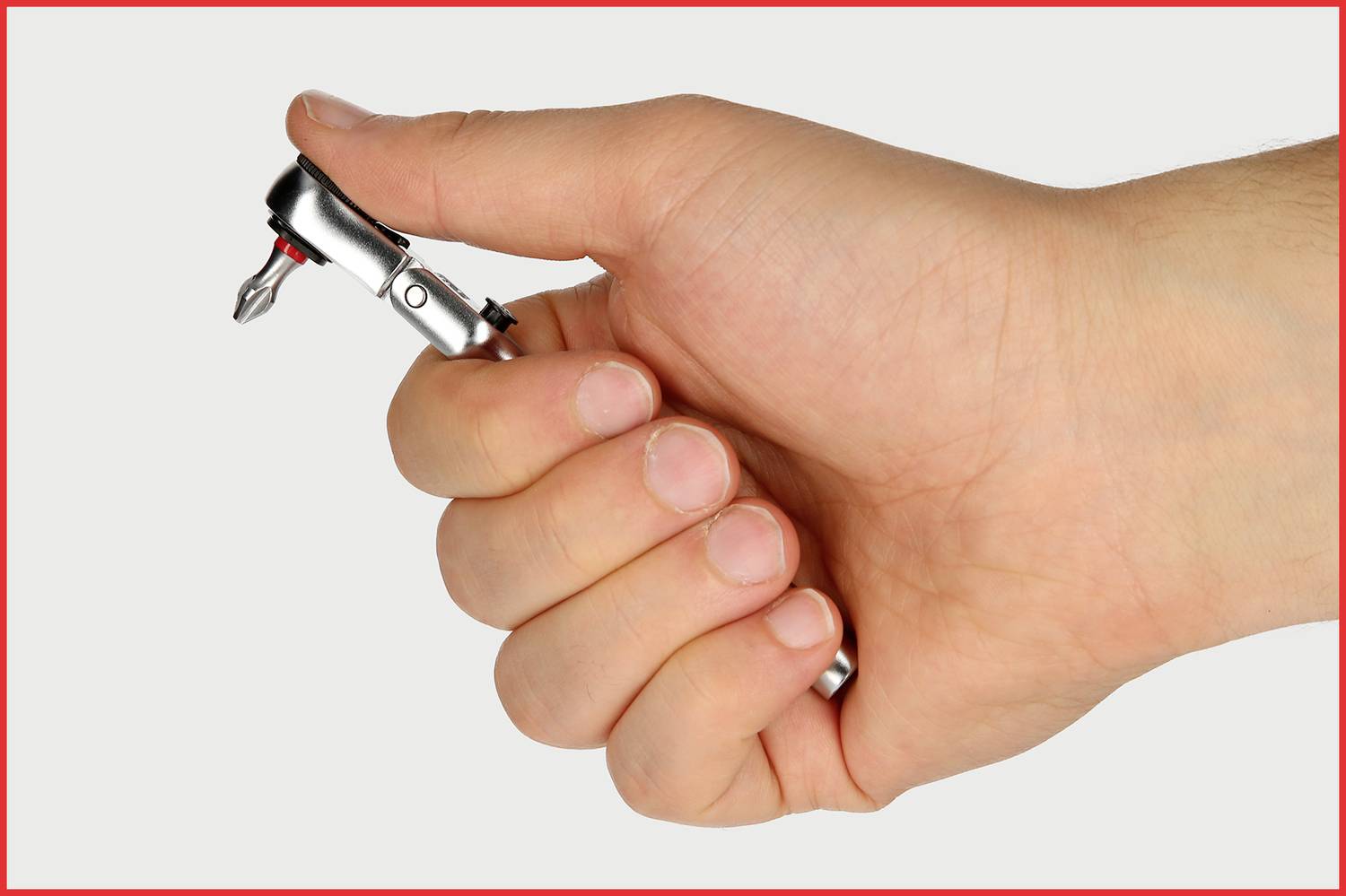 Jedna ręka trzyma małą śrubokrętkę z bitem.