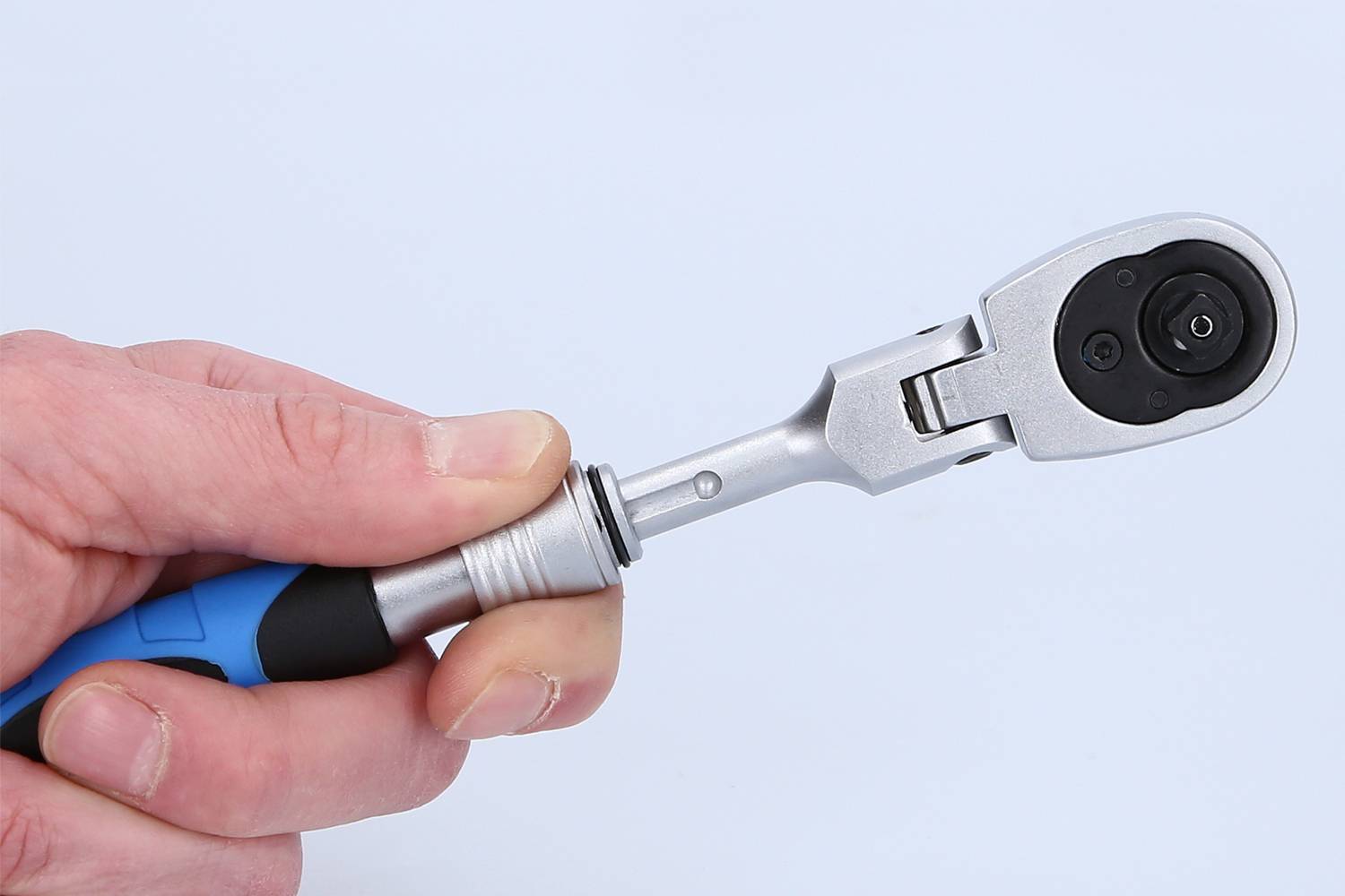 Jedna ręka trzyma klucz dynamometryczny z niebieskim uchwytem. Głowica narzędzia jest widoczna na krawędzi obrazu.