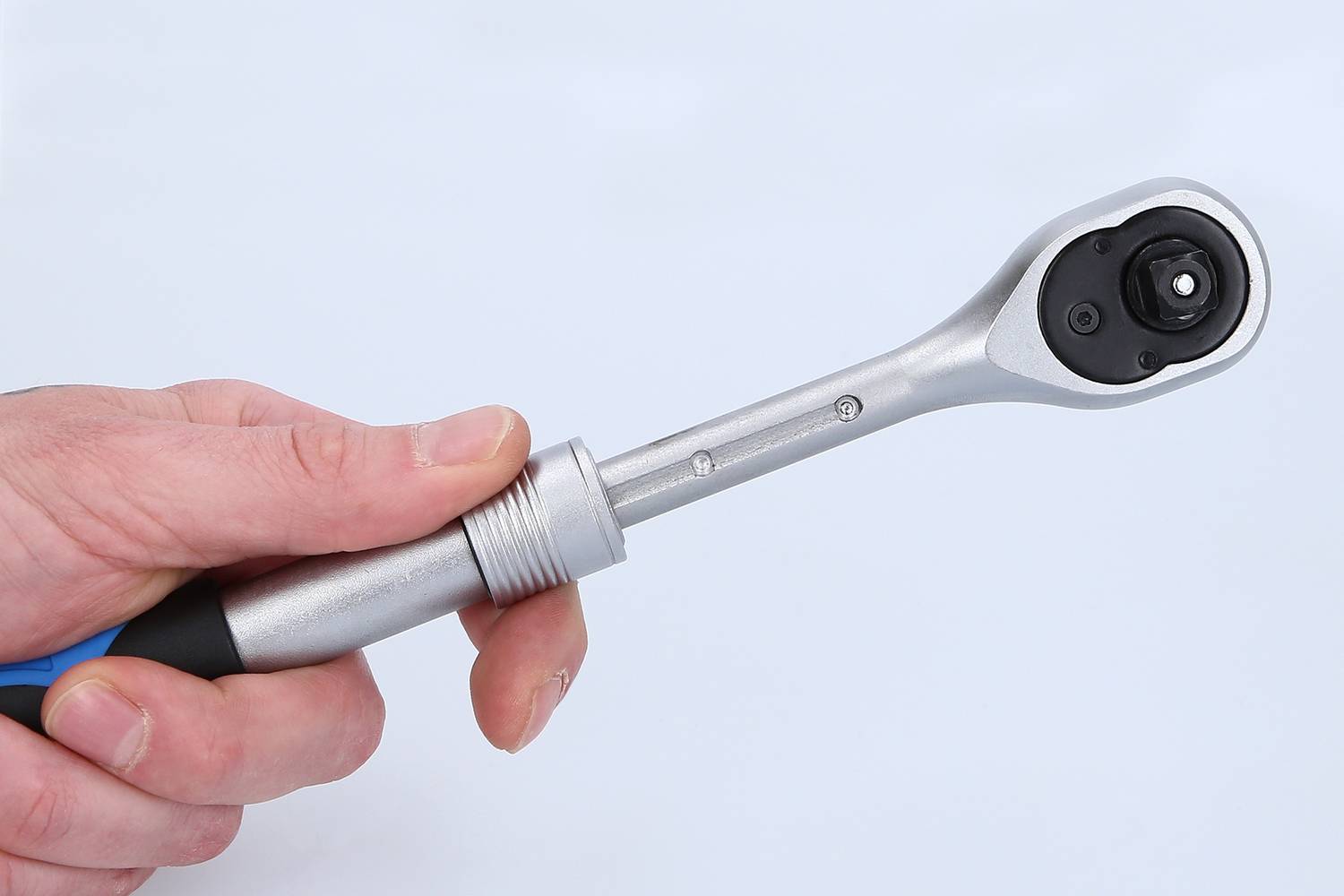 Jeden ręka trzyma nastawny klucz francuski z bliska, na białym tle.