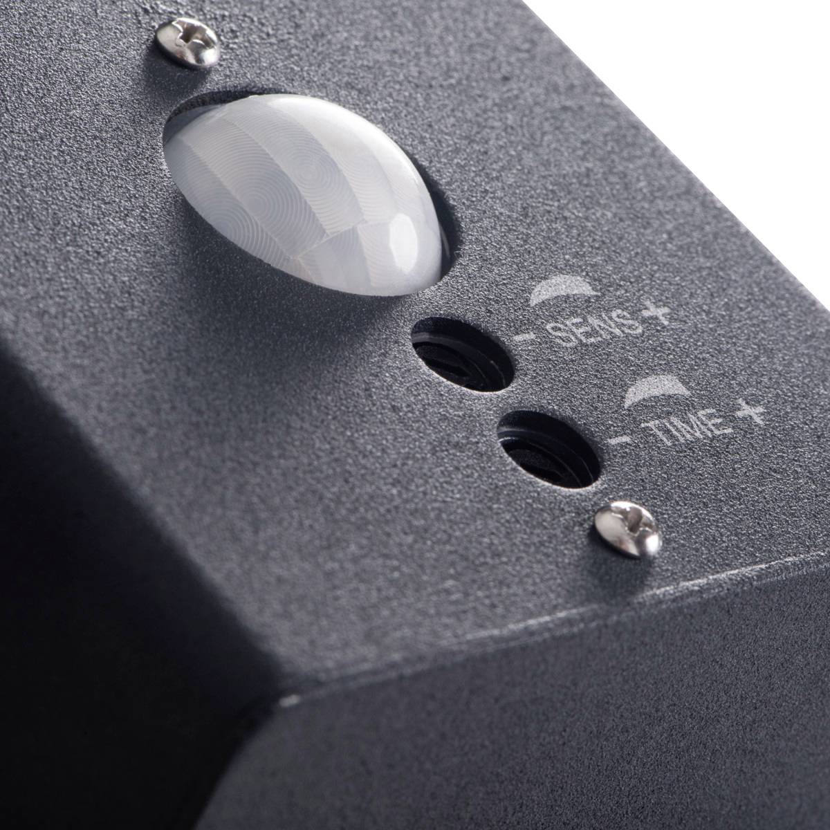 Czarne urządzenie z okrągłą, wypukłą soczewką, przyciskami 'SENS+' i 'TIME+'. Prawdopodobnie czujnik ruchu.