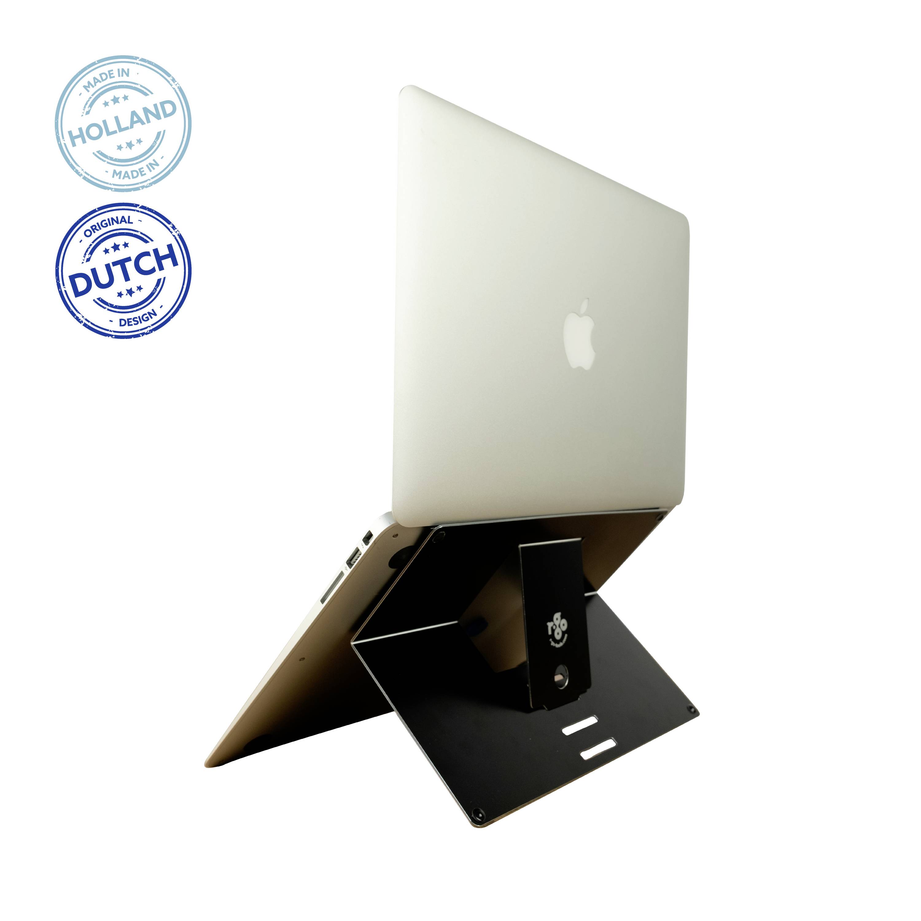 Laptop stoi na czarnym stojaku z MacBookiem. W lewym górnym rogu znajdują się dwie pieczęcie: 'Oryginalny Holenderski Design' oraz 'Wyprodukowano w Holandii'.