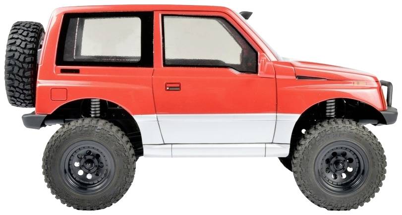 Czerwony samochodzik terenowy z dużymi kołami i kołem zapasowym z tyłu, widziany z boku.