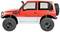 Czerwony i biały zabawkowy samochód terenowy z dużymi oponami do jazdy w terenie, widziany z boku.