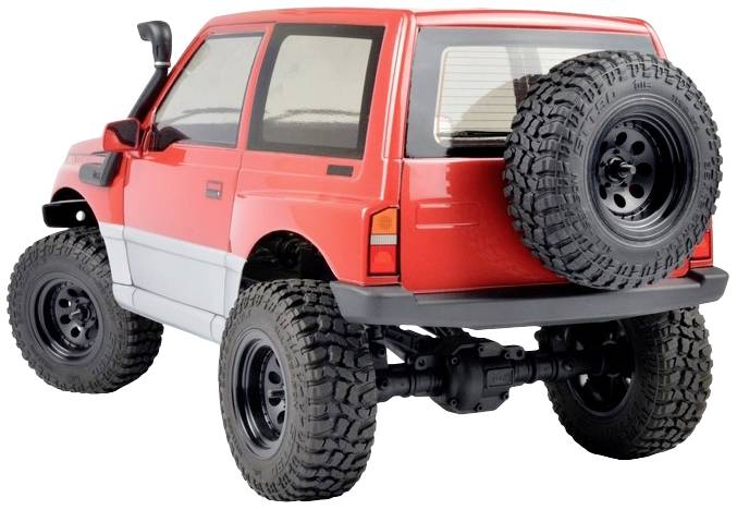 Czerwony zabawkowy samochód terenowy z dużymi kołami i kołem zapasowym z tyłu stoi na białym tle.