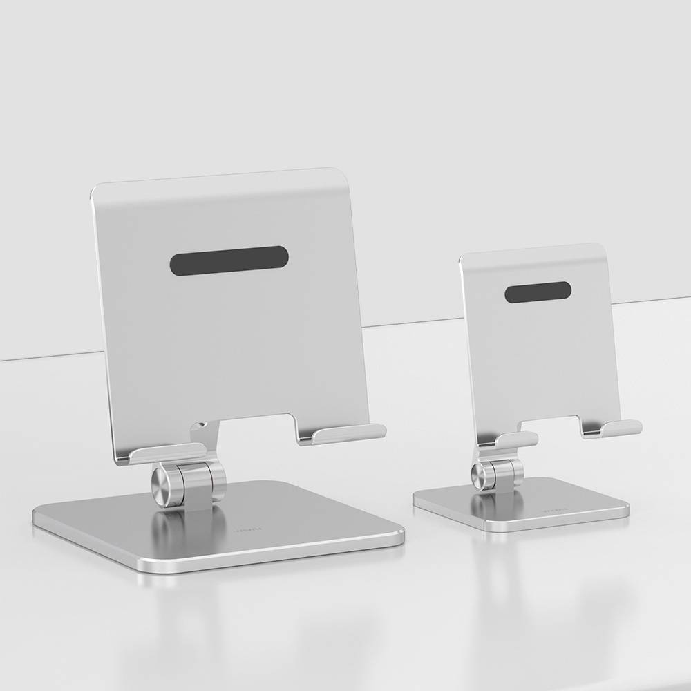 Dwa srebrne stojaki na tablet o różnych rozmiarach stoją na białej powierzchni, przeznaczone do stabilnego podtrzymywania urządzeń.