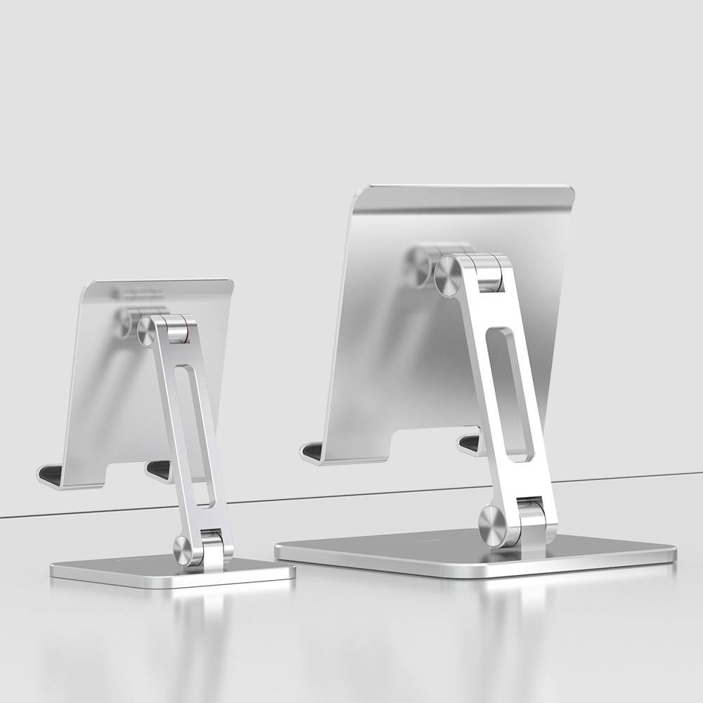 Dwa metalowe stojaki o różnych rozmiarach na biurku, służące do podtrzymywania monitorów lub tabletów.