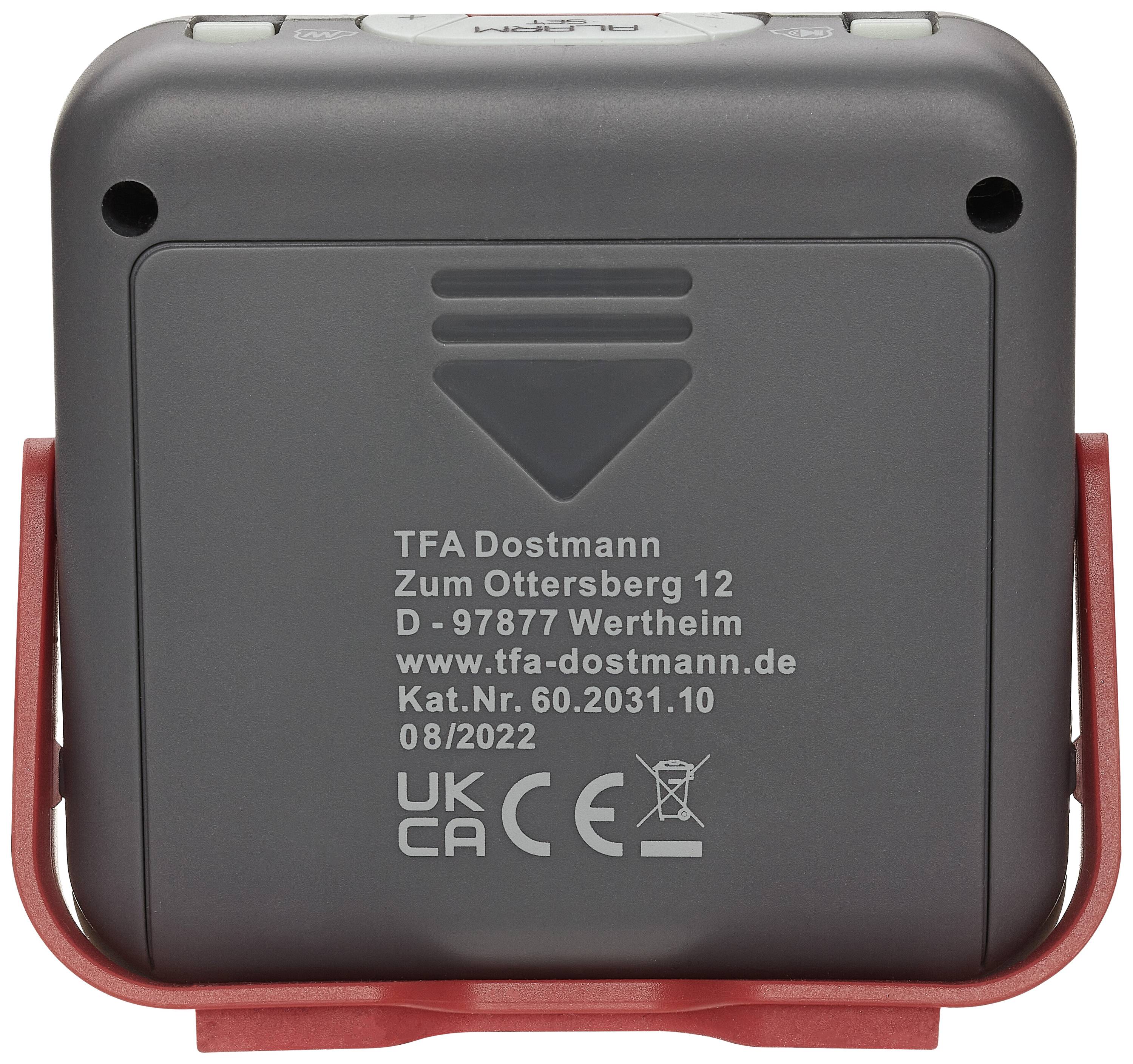 Tylna strona urządzenia elektronicznego z szarą obudową i czerwonym uchwytem. Napis wskazuje producenta, adres w Wertheim oraz informacje o produkcie.
