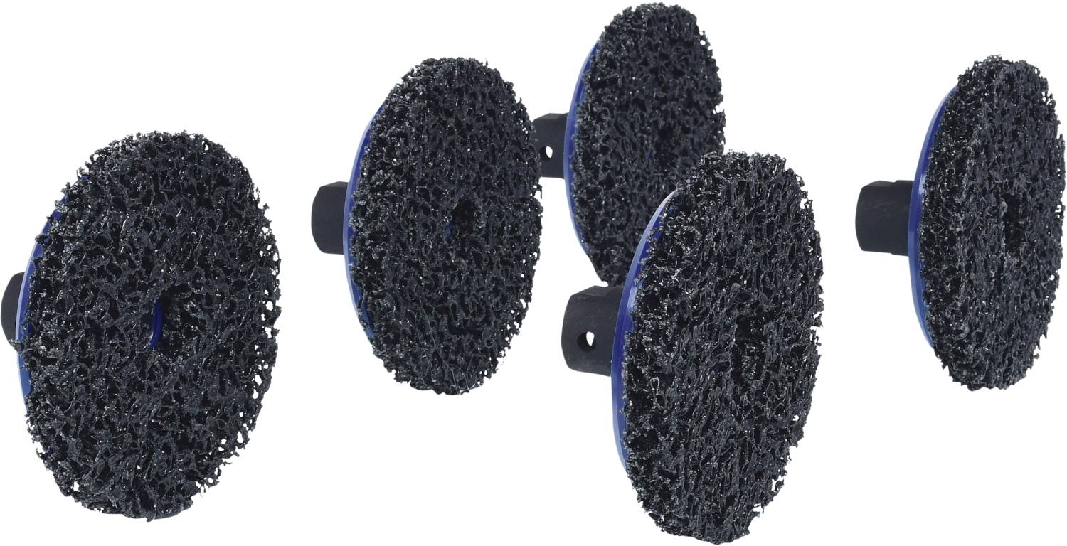 Czarne tarcze szlifierskie o szorstk fakturze, zgrupowane i ustawione pionowo. Są używane do obróbki powierzchni.