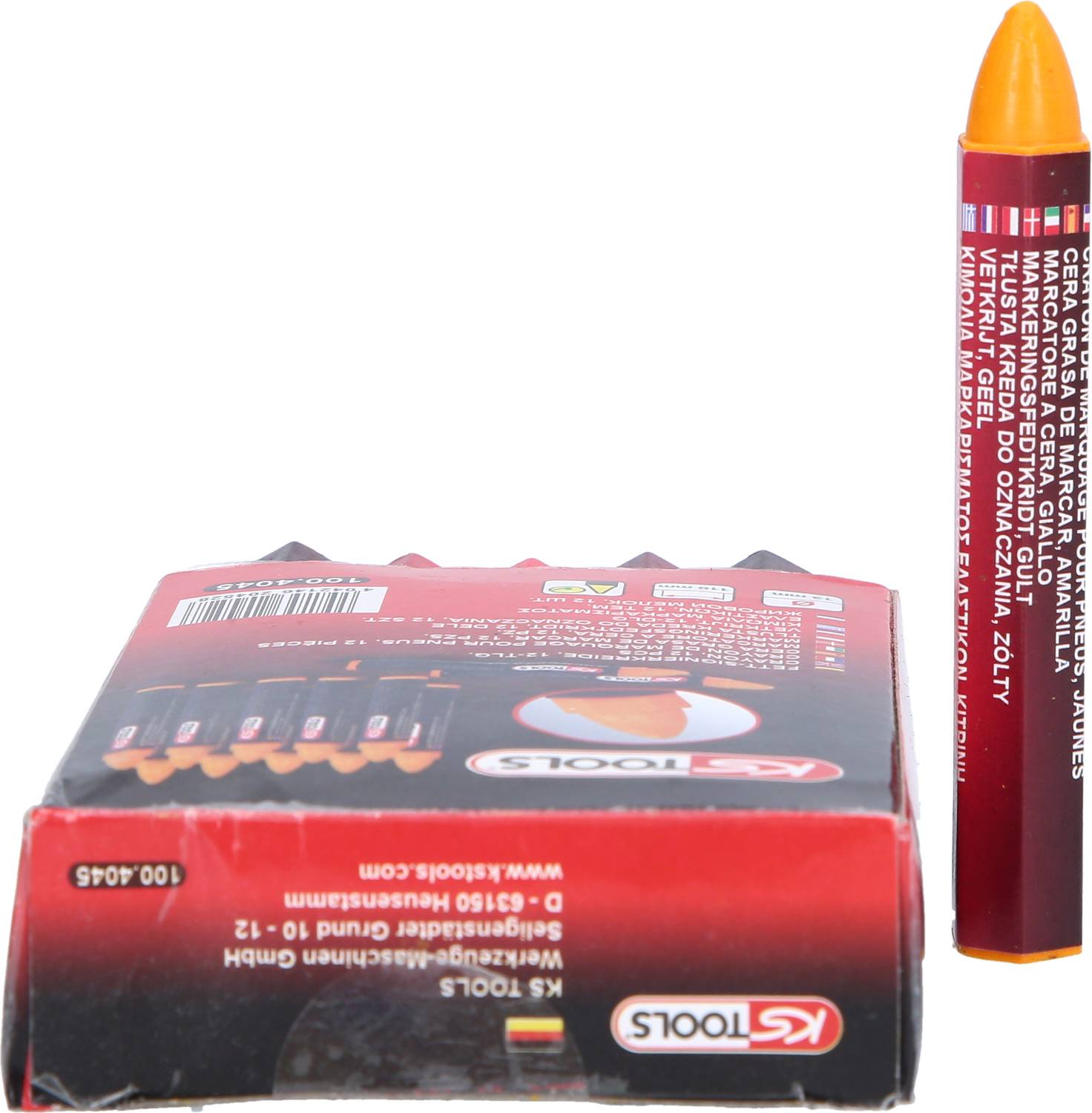 Czerwony kredka woskowa stoi pionowo obok otwartego opakowania z pozostałymi kredkami.