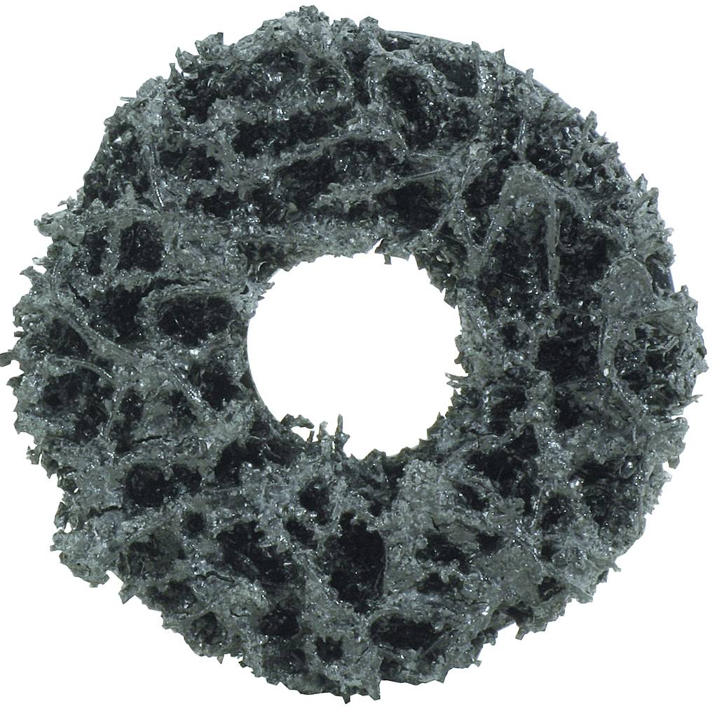 Ciemny, szorstki obiekt w kształcie donuta o nierównej powierzchni z otworem pośrodku, sfotografowany na białym tle.