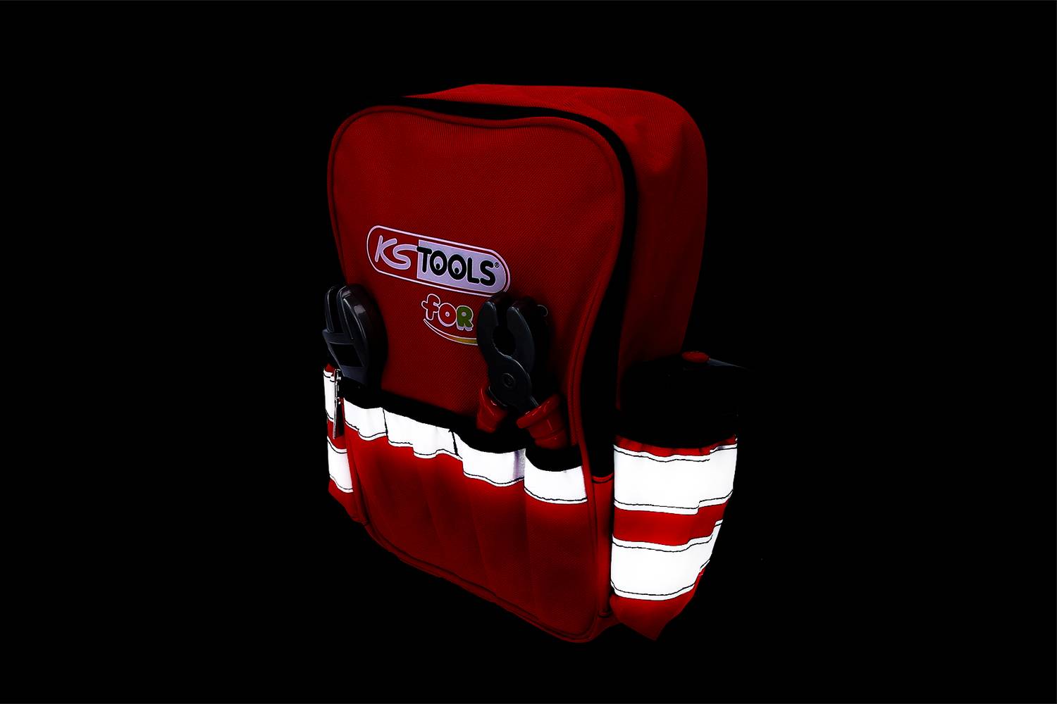 Czerwony plecak na narzędzia marki KS Tools z odblaskowymi paskami. Do haczyków po bokach podwieszono różne narzędzia.