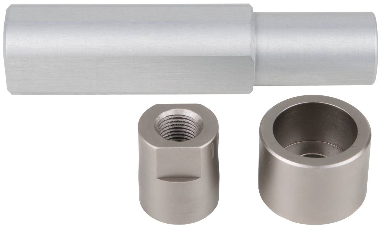 Metalowy element maszynowy: cylindryczna część i dwa mniejsze elementy cylindryczne, jeden z gwintem, drugi otwarty.