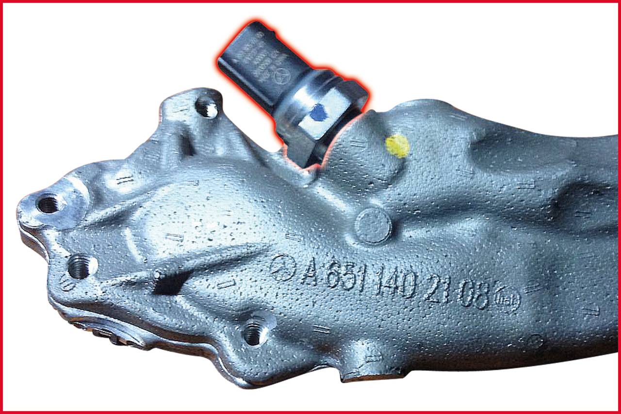 Szary czujnik metalowy na elemencie mechanicznym z numerem części A6311402108.