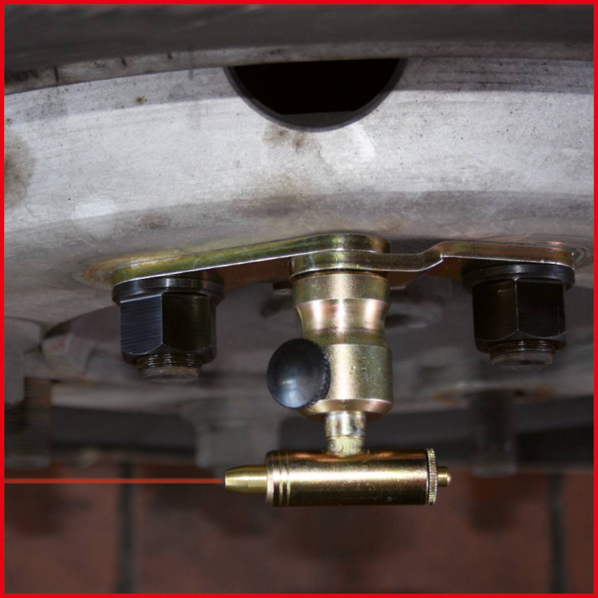 Zbliżenie opony samochodowej z zamontowanym czujnikiem TPMS (systemu kontroli ciśnienia w oponach), przymocowanym do felgi.