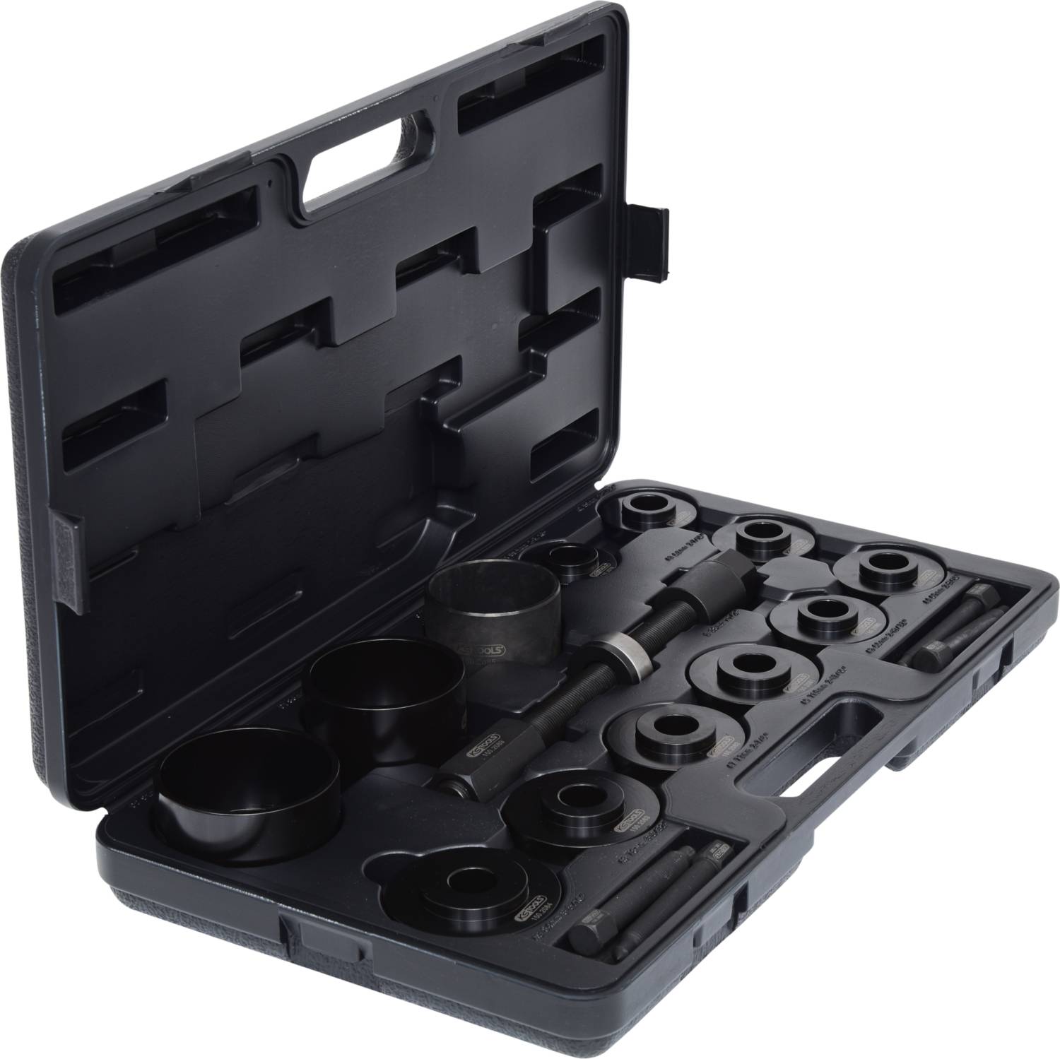 Czarny kufer narzędziowy z różnymi okrągłymi nasadkami i elementami wyposażenia, ułożonymi w regularnym porządku, przeznaczony do naprawy pojazdów.