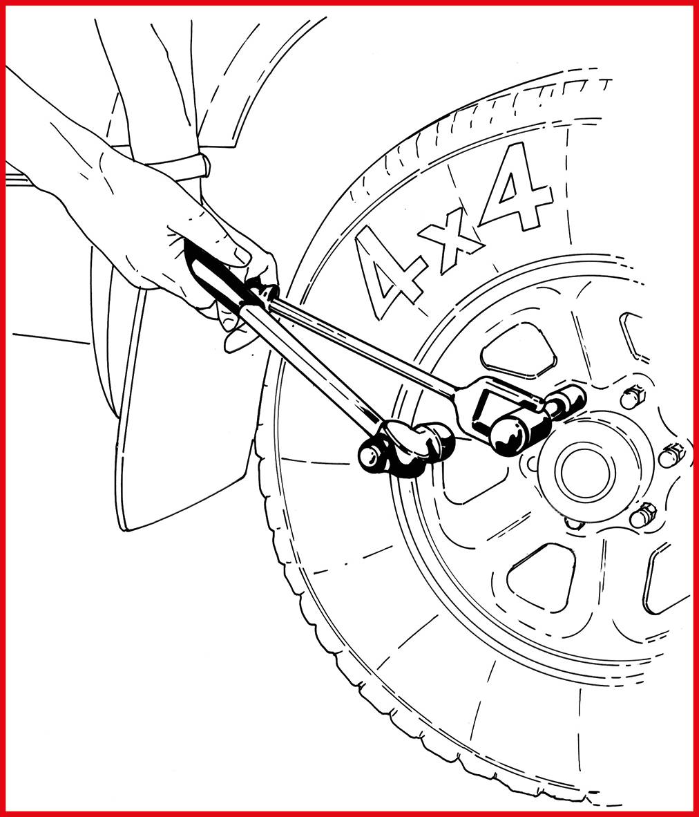 Dłoń używa klucza krzyżowego do odkręcenia nakrętek koła pojazdu terenowego 4x4. Koło jest częściowo widoczne.