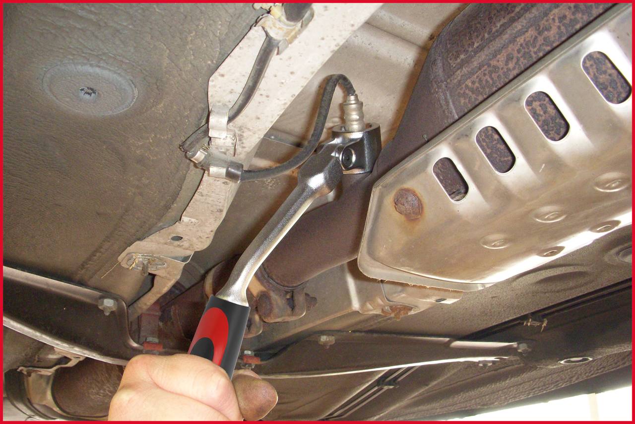 Jedna ręka dokręca śrubę kluczem na podwoziu pojazdu.